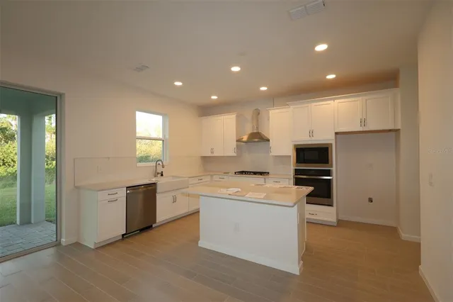 a kitchen with stainless steel appliances granite countertop a sink and stove top oven