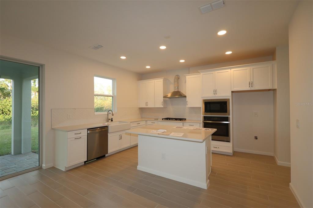 5426 Park Guell Street St. Cloud, FL 34771 - Photo 8 of 64 a kitchen with stainless steel appliances granite countertop a sink and stove top oven