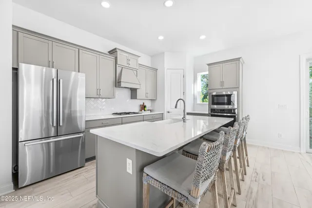 a kitchen with kitchen island a sink stove and refrigerator