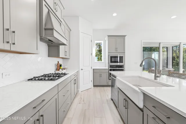 a kitchen with granite countertop a sink stove and cabinets