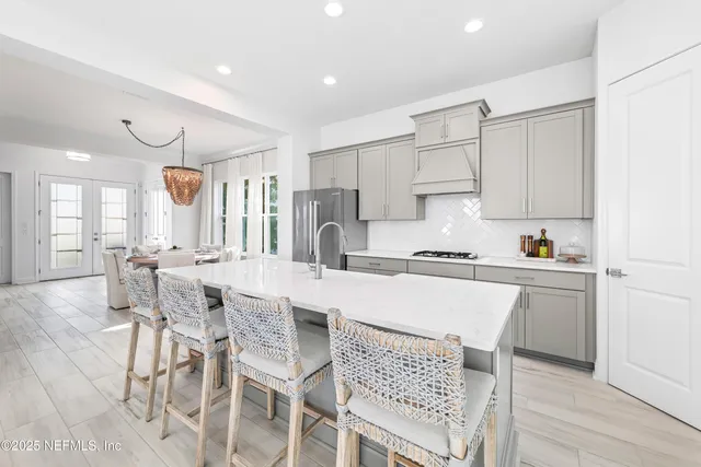 a kitchen with a table chairs a sink dishwasher and cabinets with wooden floor