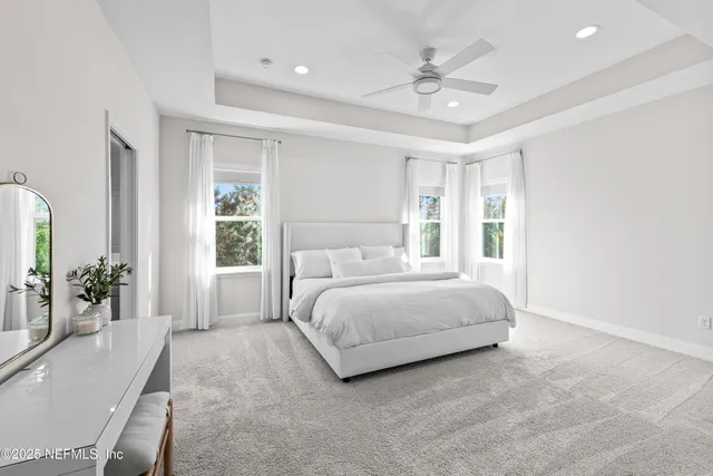 a spacious bedroom with a large bed a chandelier and a large window