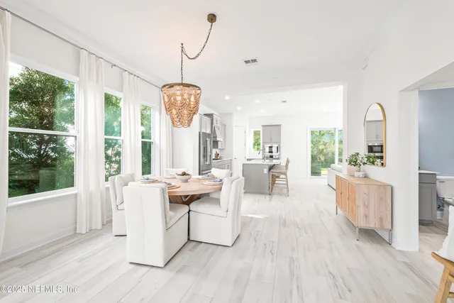 a living room with furniture a large window and wooden floor