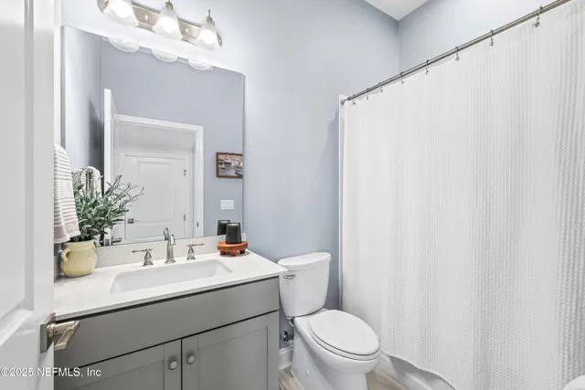 a bathroom with a sink vanity mirror and toilet