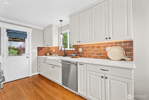 a kitchen with granite countertop white cabinets and white appliances