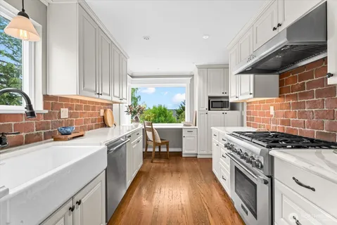 a kitchen with a sink stove top oven and cabinets