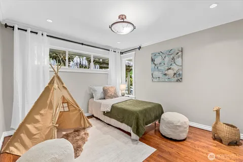 a bedroom with a bed and wooden floor