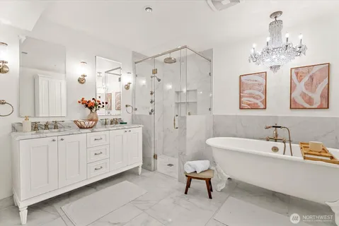 a spacious bathroom with a double vanity sink a mirror a bathtub and a shower