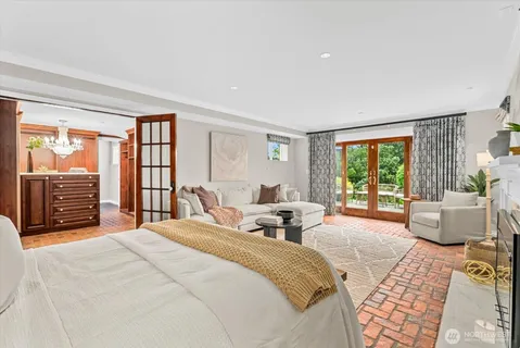 a bedroom with a bed and large windows