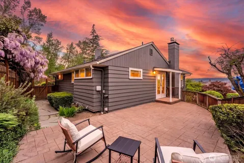 a backyard of a house with table and chairs