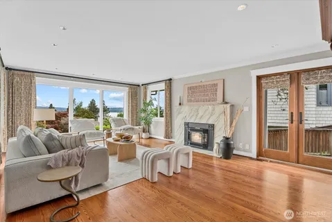a living room with fireplace furniture and a large window