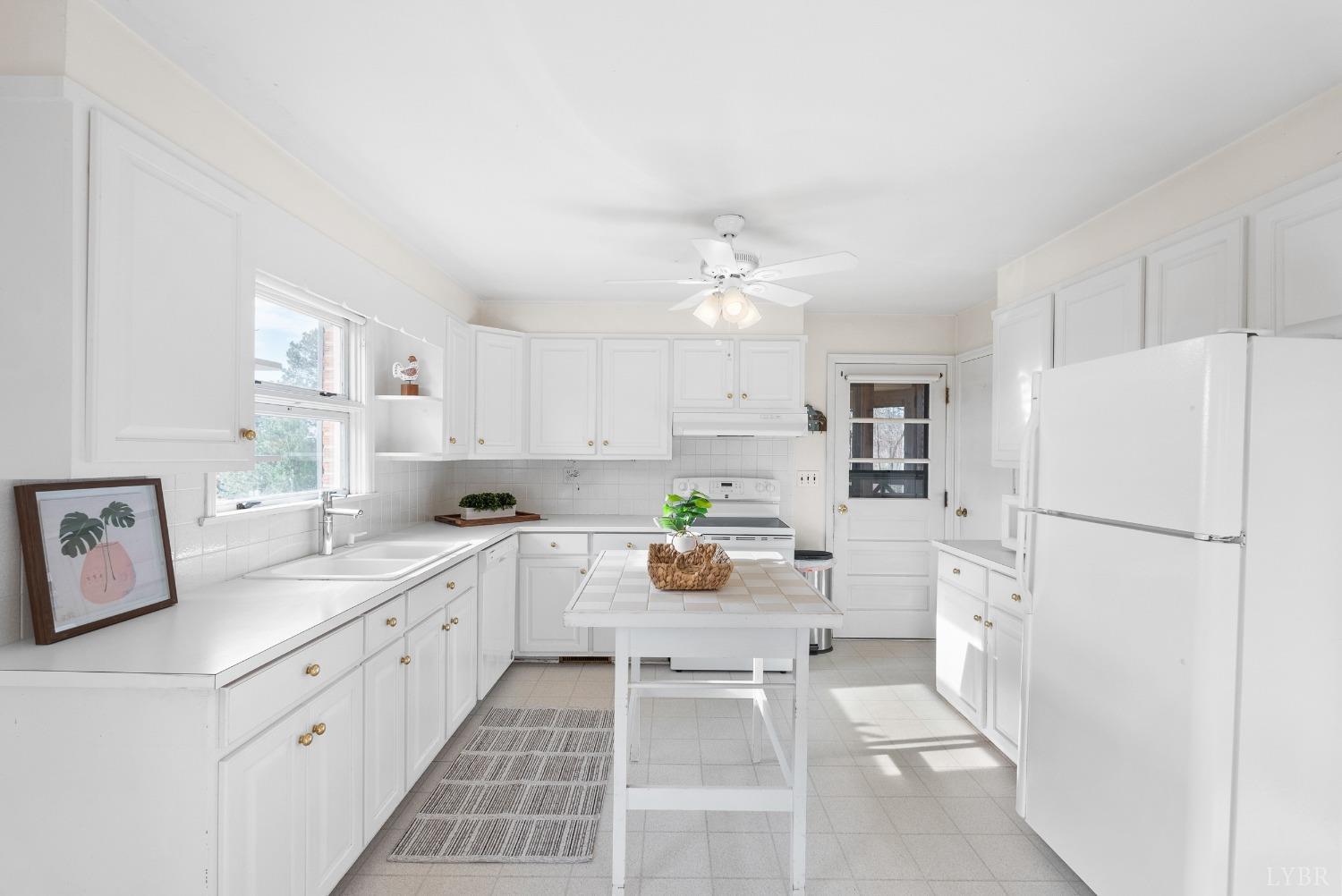 907 High Peak Road Monroe, VA 24574 - Photo 13 of 61 a kitchen with white cabinets and white appliances