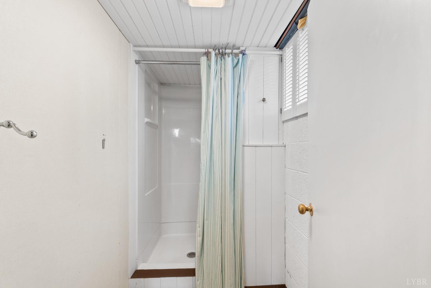 907 High Peak Road Monroe, VA 24574 - Photo 32 of 61 a bathroom with a glass shower door