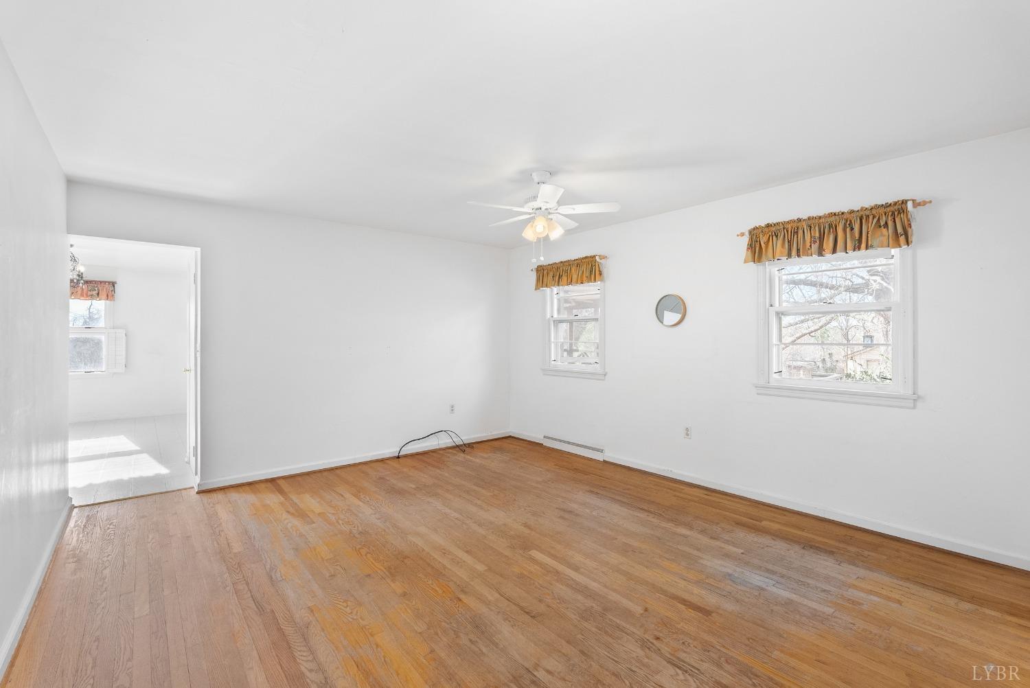 907 High Peak Road Monroe, VA 24574 - Photo 9 of 61 an empty room with wooden floor and windows