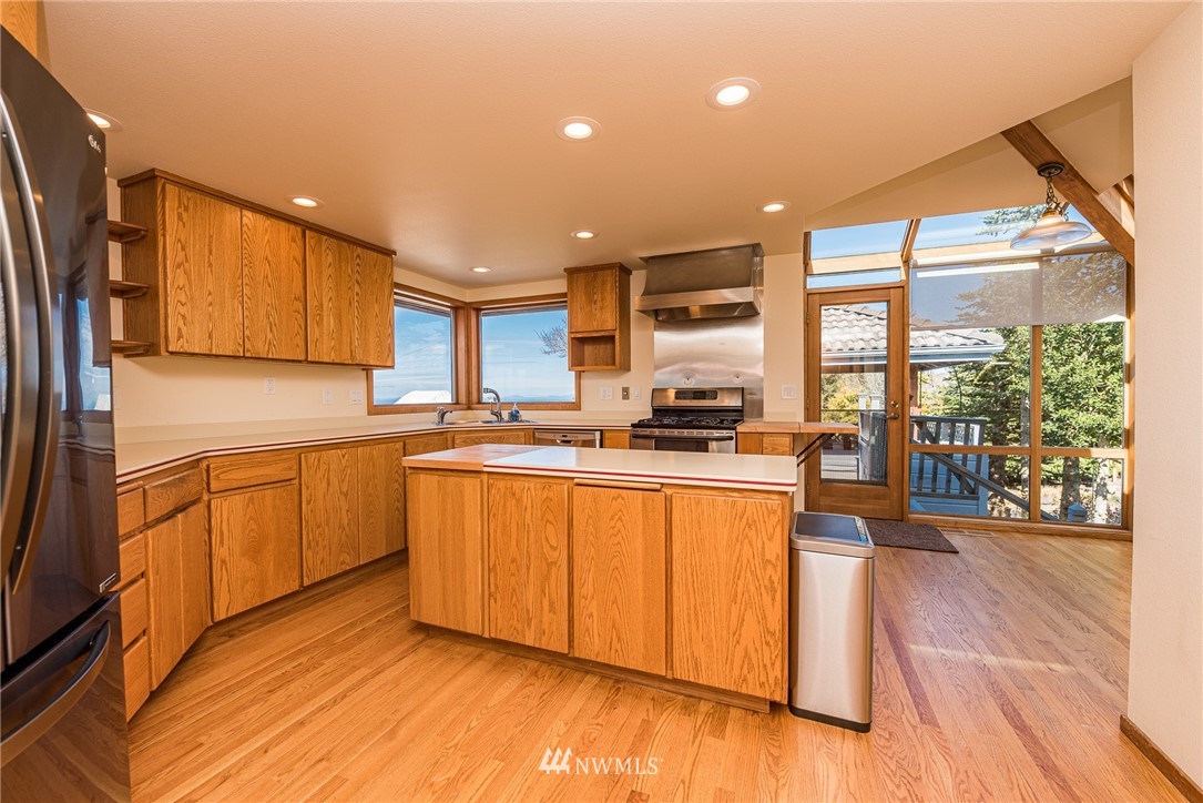 543 Ravens Ridge Road Sequim, WA 98382 - Photo 11 of 40 a kitchen with stainless steel appliances granite countertop a stove a sink and a refrigerator with wooden floor