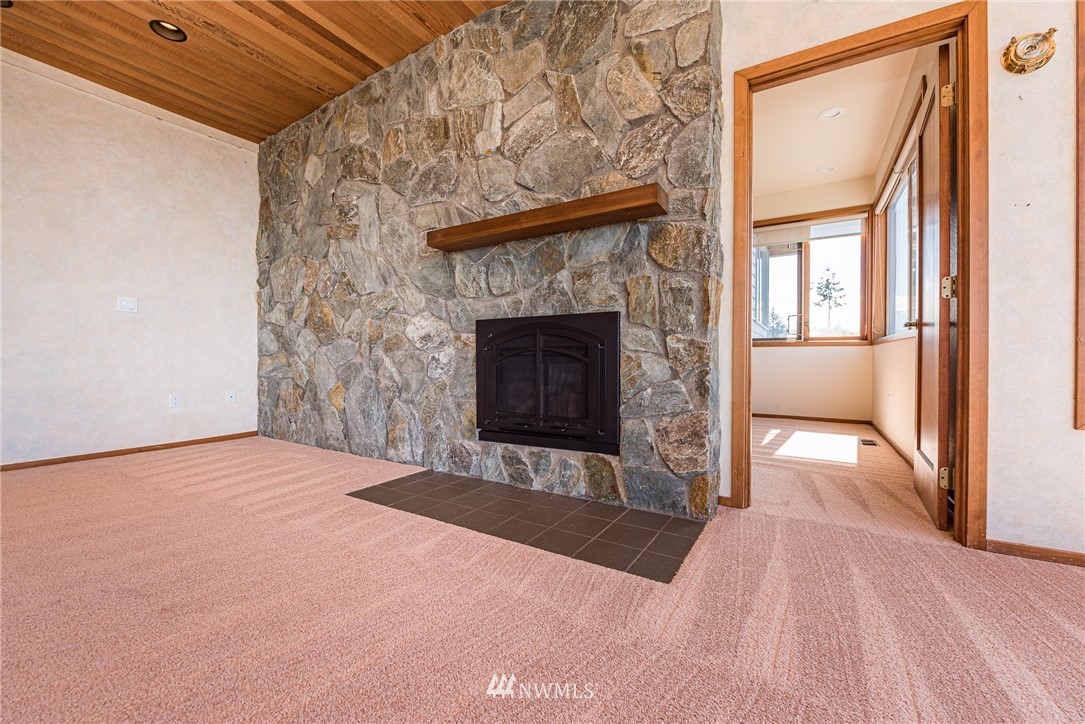 543 Ravens Ridge Road Sequim, WA 98382 - Photo 19 of 40 a view of an empty room with a fireplace and a window
