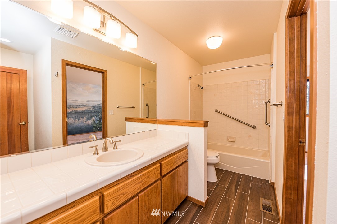 543 Ravens Ridge Road Sequim, WA 98382 - Photo 24 of 40 a bathroom with a sink a toilet a mirror and shower