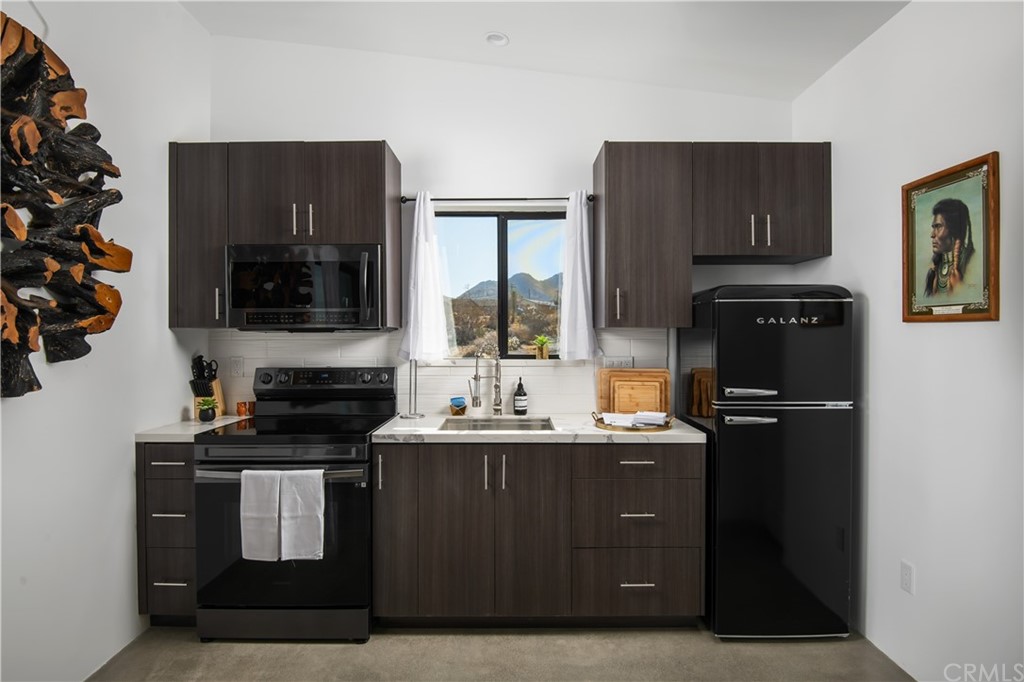 a kitchen with stainless steel appliances granite countertop a stove a refrigerator and a microwave