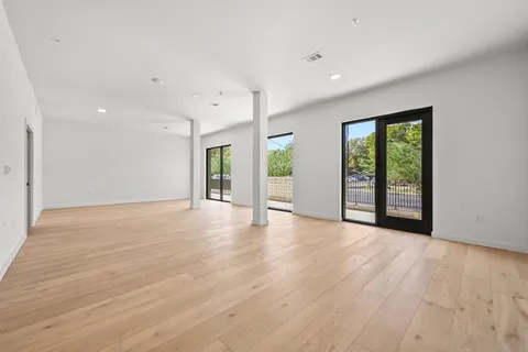 a view of an empty room with wooden floor
