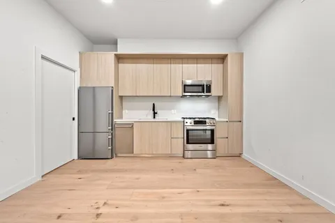 a kitchen with stainless steel appliances a stove a microwave and a refrigerator