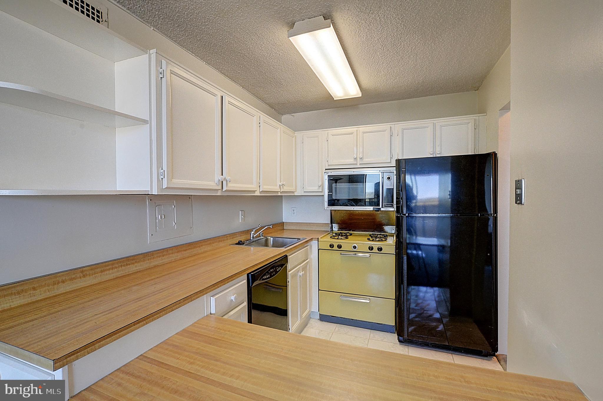 5225 Pooks Hill Road, Unit 1717S Bethesda, MD 20814 - Photo 7 of 12 a kitchen with stainless steel appliances a stove a refrigerator and cabinets