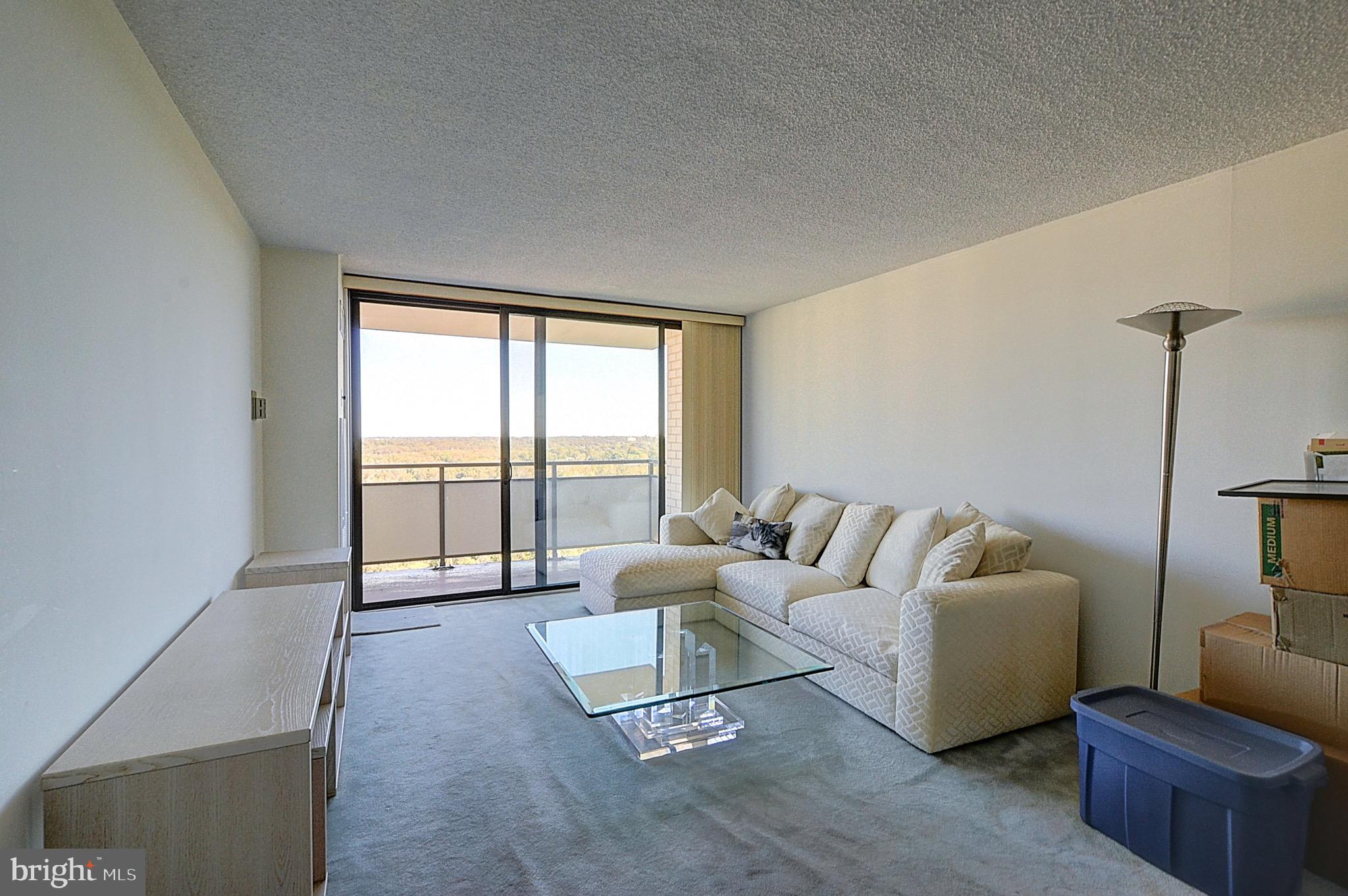 5225 Pooks Hill Road, Unit 1717S Bethesda, MD 20814 - Photo 9 of 12 a living room with furniture and a floor to ceiling window
