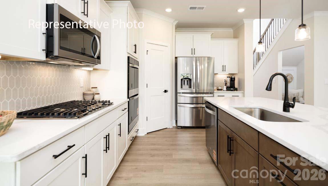 3117 Spring Iris Drive Denver, NC 28037 - Photo 38 of 42 a kitchen with stainless steel appliances a sink stove and refrigerator