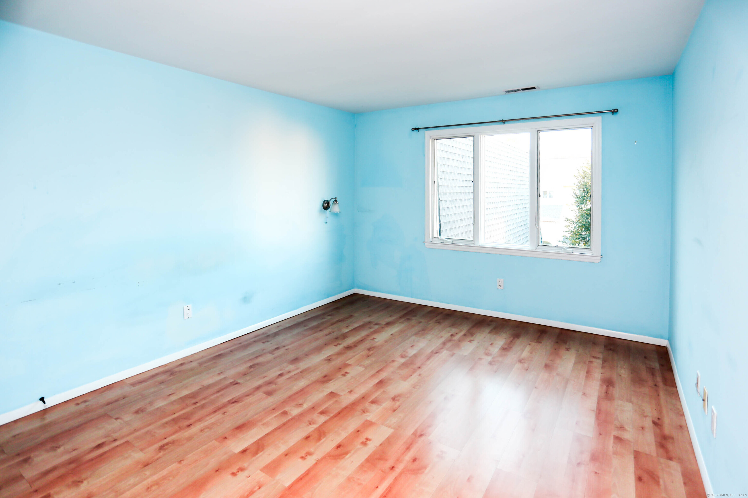61 Seaview Avenue, Unit 51 Stamford, CT 06902 - Photo 12 of 27 an empty room with wooden floor and windows