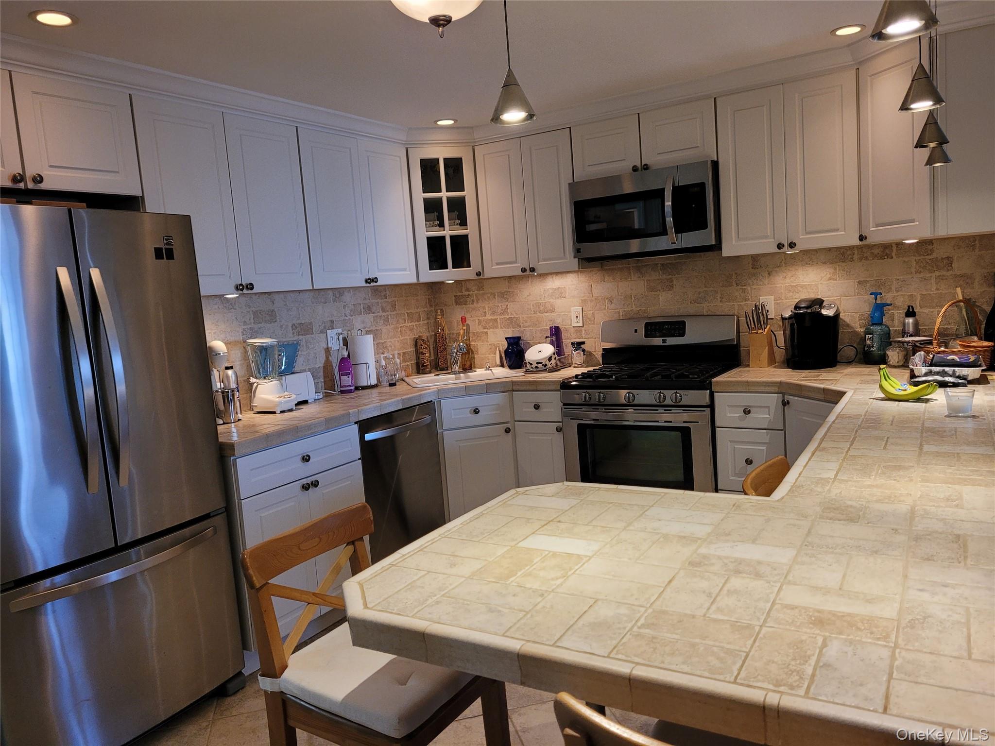 79 Rochester Avenue, Unit GARDEN Long Beach, NY 11561 - Photo 6 of 15 a kitchen with stainless steel appliances granite countertop a refrigerator sink stove microwave and cabinets