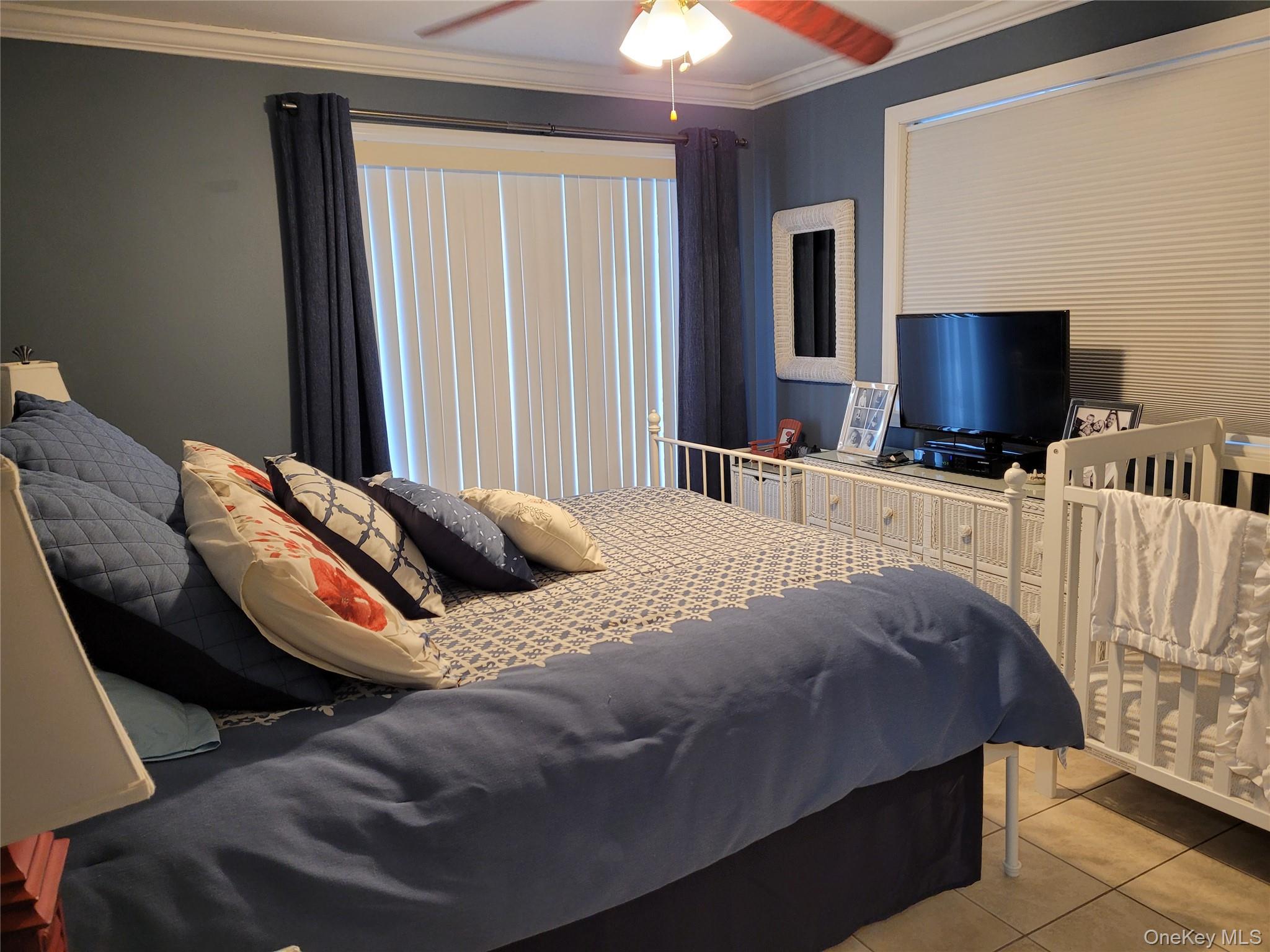 79 Rochester Avenue, Unit GARDEN Long Beach, NY 11561 - Photo 9 of 15 a bedroom with a bed and a flat screen tv