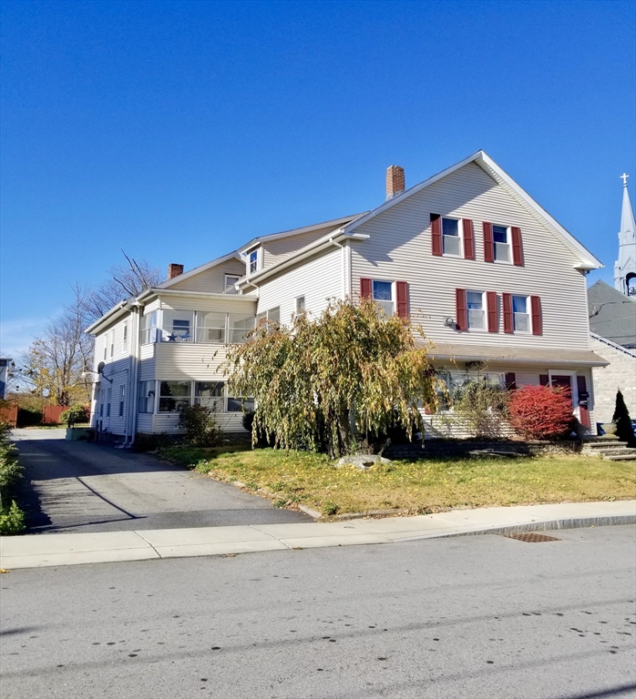 a view of a house with big yard and large trees