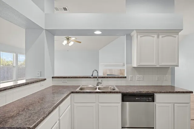 a kitchen with granite countertop a sink and cabinets