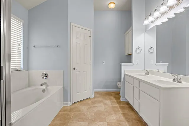 a spacious bathroom with a tub sink and mirror