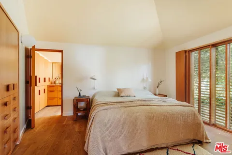 a bed sitting in a bedroom next to a window