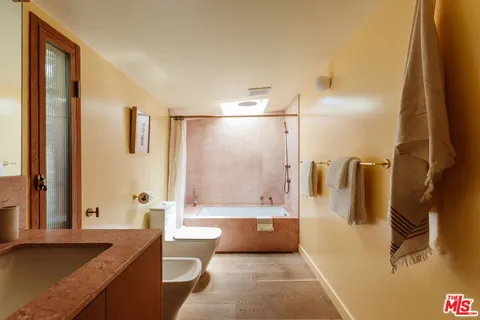 a bathroom with a granite countertop sink a mirror and a bathtub