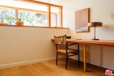 a view of a workspace with furniture and a window