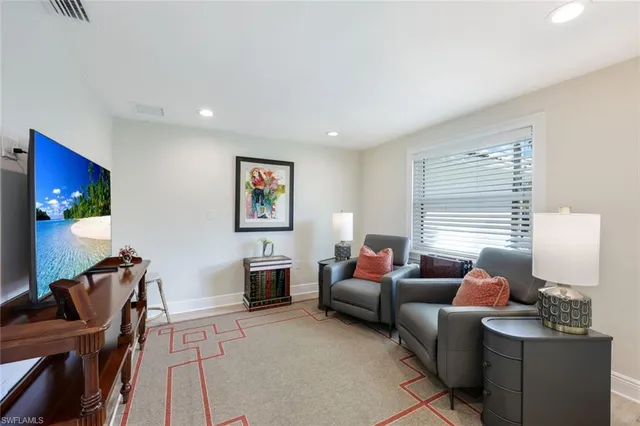 a living room with furniture a window and a flat screen tv