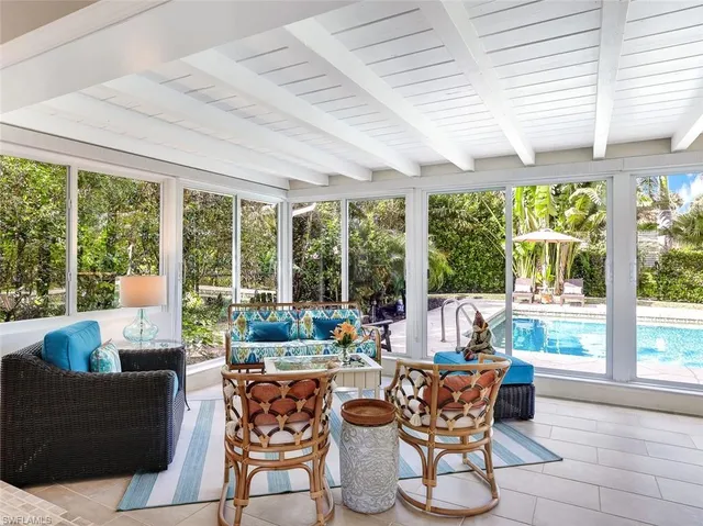 a dining room with furniture large windows and wooden floor