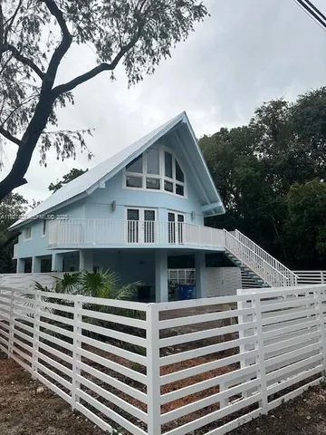 a house that has a tree in front of the house