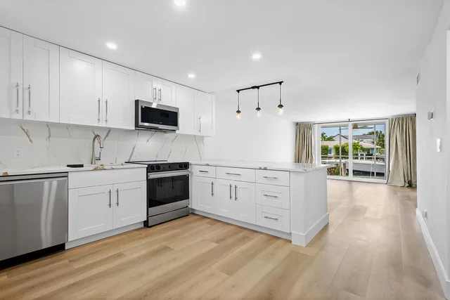 a kitchen with white cabinets and stainless steel appliances