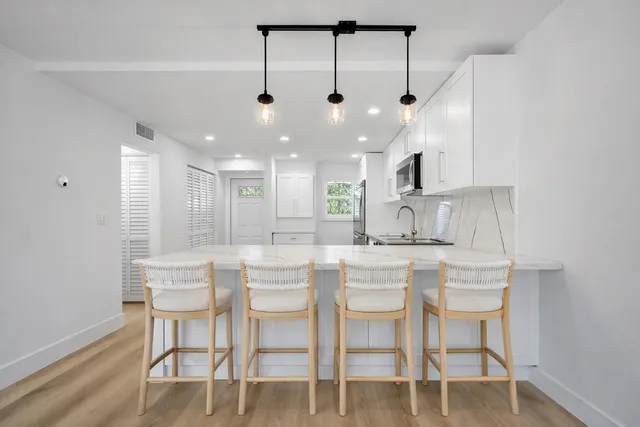 a view of a big room with wooden floor and windows