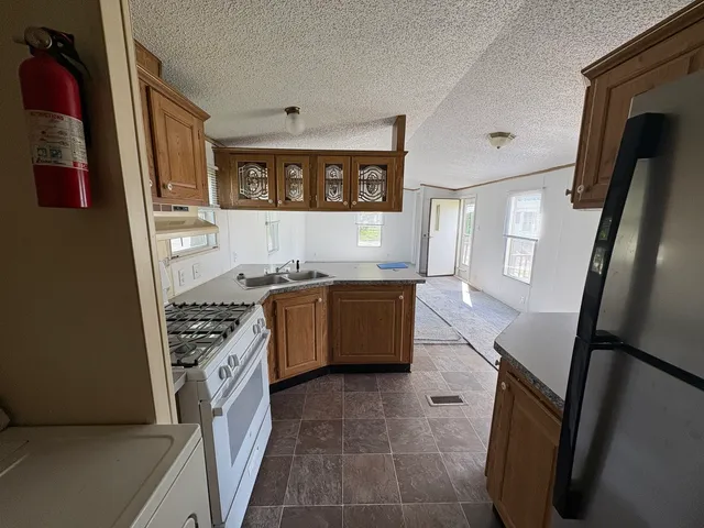a kitchen with stainless steel appliances granite countertop a stove a sink and a refrigerator