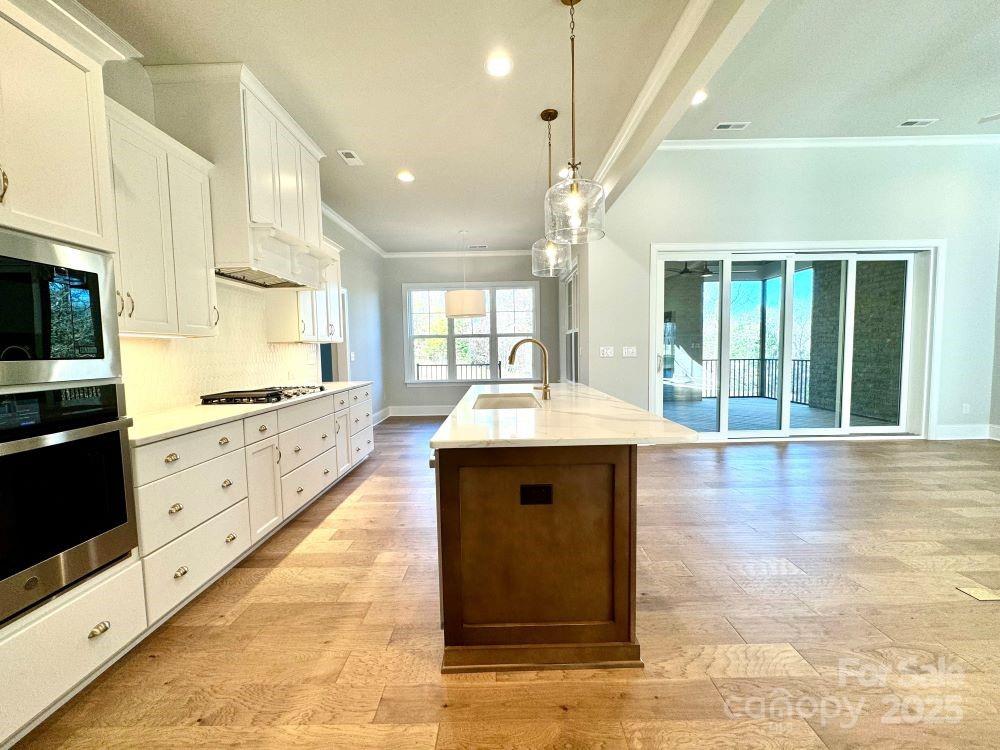 3850 Willow Grove Lane, Unit 24 Concord, NC 28025 - Photo 11 of 40 a large white kitchen with kitchen island a sink stainless steel appliances and cabinets