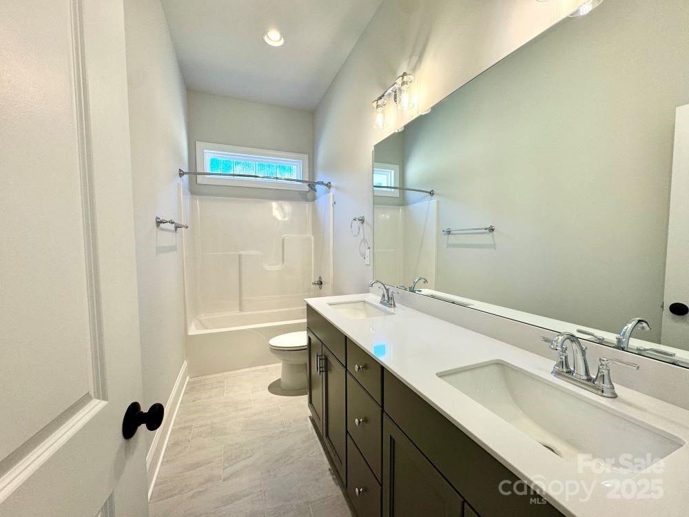 3850 Willow Grove Lane, Unit 24 Concord, NC 28025 - Photo 33 of 40 a bathroom with a granite countertop sink mirror and a bathtub