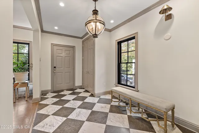 a view of a hallway with windows and chandelier
