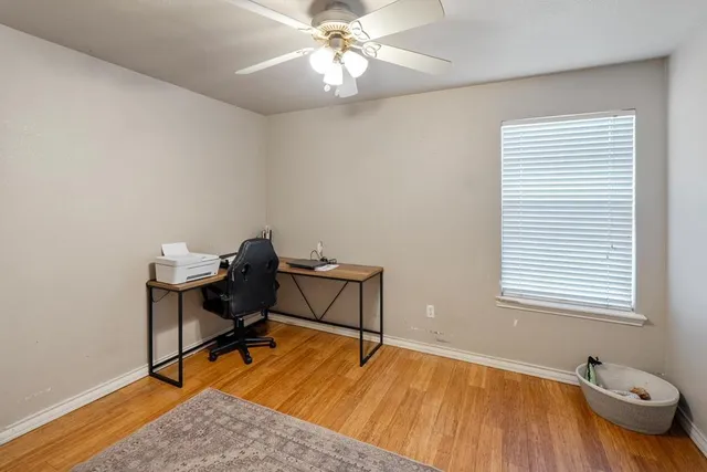a view of a workspace with furniture and a window