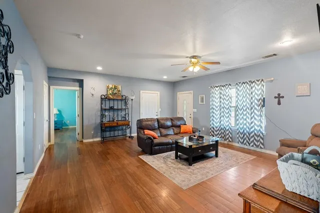 a living room with furniture and a wooden floor