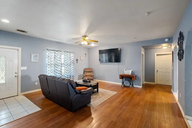 a living room with furniture and a wooden floor