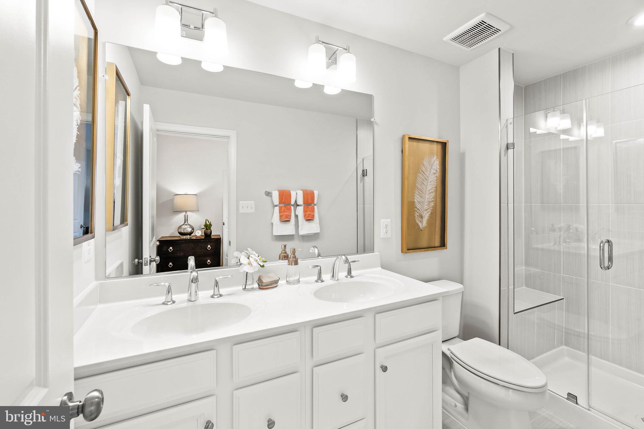 7109 Gladebrook Road Brandywine, MD 20613 - Photo 9 of 26 a bathroom with a sink a toilet a mirror and shower