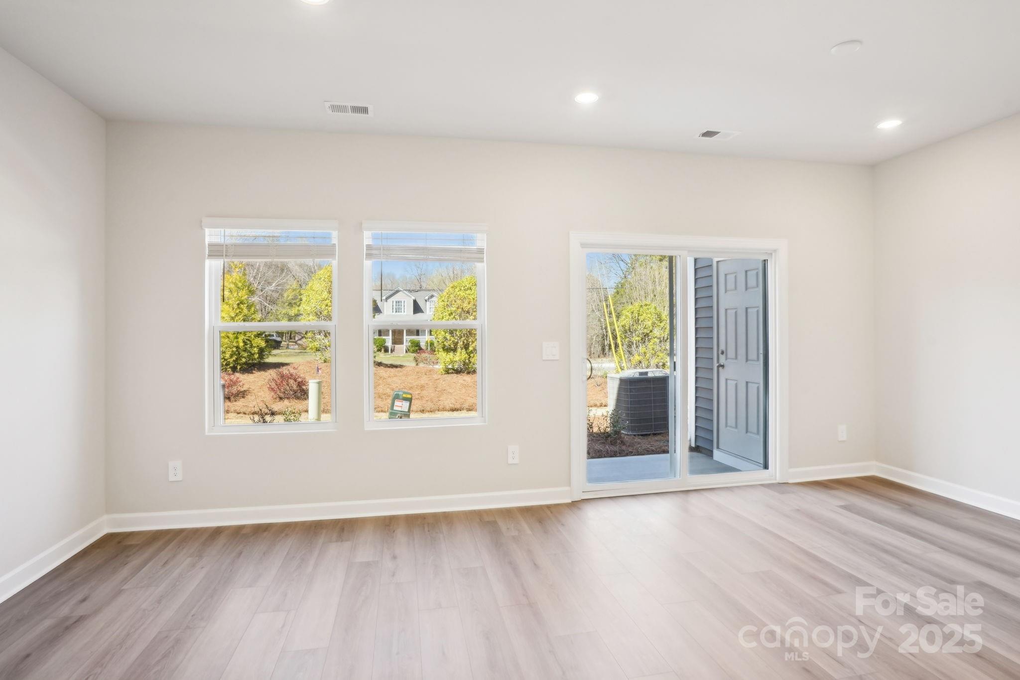 1413 Old Rivers Road Concord, NC 28027 - Photo 4 of 20 an empty room with wooden floor and windows